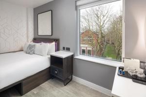 ロンドンにあるFour Points Flex by Sheraton London Shoreditch Eastのベッドと窓のある寝室