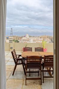 a table and chairs on a balcony with a view at VESTA - Heliopolis Residence in Cairo