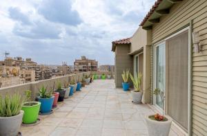 a balcony with a row of potted plants at VESTA - Heliopolis Residence in Cairo