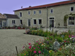 a building with a bunch of flowers in front of it at La Ferme Pateli in Courouvre