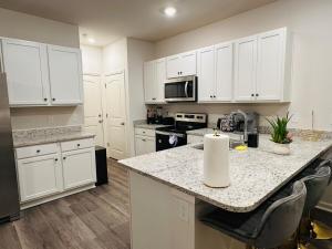 a kitchen with white cabinets and a granite counter top at Modern comfort house in Madison +19 photos