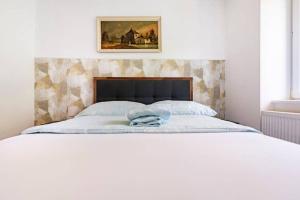 a bedroom with a bed with a picture on the wall at Maison de Maître in Tramelan
