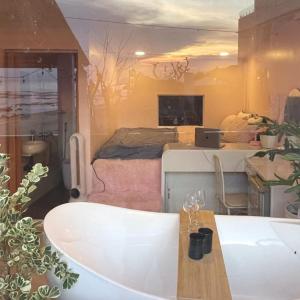 una stanza con vasca da bagno e una camera da letto di Rosy House Đảo Phú Quý a Cù Lao Thu