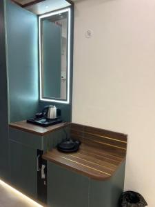 a bathroom with a counter with a mirror and a sink at My Guest Stay at Omaxe Hazratganj in Lucknow