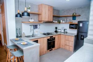 a kitchen with wooden cabinets and a black refrigerator at Hogar de Olas Huanchaco in Huanchaco