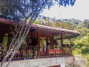 a house with a balcony with red chairs on it at Creek Downhills in Ella