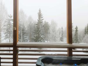 a window with a view of a snow covered forest at Pärjä Suites 2 in Syöte
