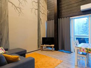 a living room with a couch and a tv at Pärjä Suites 2 in Syöte
