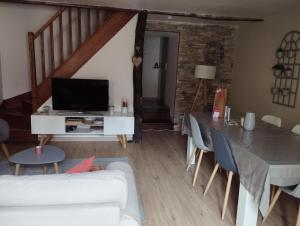 a living room with a white couch and a tv at La maison de Marie, cosy et spacieuse - 3 chambres dont une climatisée in Châtillon-sur-Chalaronne
