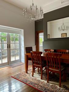 a dining room with a table and chairs and a chandelier at Charming Heritage Home in Launceston