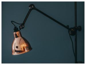a metal light hanging from a black pole at 1.75 Paris Le Charme in Paris