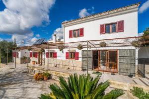 a white house with red windows and a courtyard at Ideal Property Mallorca - Ca Na Venta in Lloret de Vistalegre