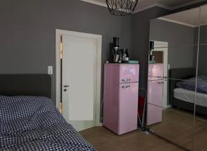 a bedroom with a pink refrigerator and a mirror at Bett 4 you Hamburg-Alster in Hamburg