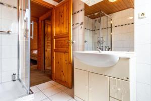 a bathroom with a sink and a shower and a tub at Feriendorf Blauvogel Blauvogel 054 in Hasselfelde +16 photos