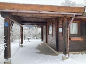 a wooden cabin in the snow with a door open at Hasselhäuser Hasselhaus 4 in Hasselfelde