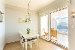 杜布羅夫尼克的住宿－Apartment Lividus A7，一间设有白色桌椅和窗户的用餐室