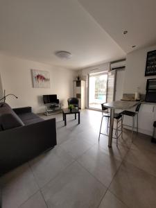 ein Wohnzimmer mit Sofa und Tisch in der Unterkunft Beau Studio climatisé, parking privé Sanary centre in Sanary-sur-Mer