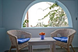 two chairs and a table with a bowl of oranges at Celeste NAXOS Chora in Naxos Chora