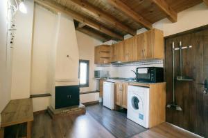 a kitchen with a washing machine and a microwave at Ca de l'Estall in Estopiñán