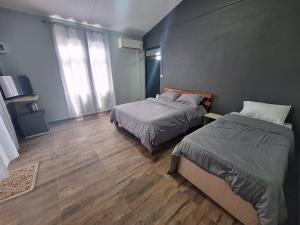 a bedroom with two beds and a wooden floor at Horizon Lodge in Diamond Island
