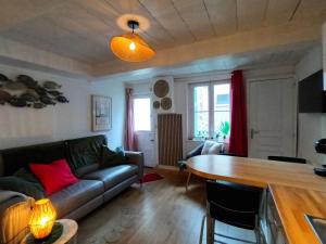 a living room with a couch and a table at La P'tite Normande in Villerville