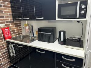 a kitchen counter with a sink and a microwave at Luxury City Apartments, Downtown Loft House with Private Sauna in Rovaniemi +9 photos