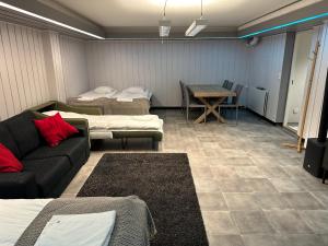 a room with three beds and a couch and a table at Luxury City Apartments, Downtown Loft House with Private Sauna in Rovaniemi