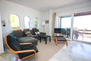 a living room with a couch and chairs and windows at Three bedroom apartment La Mairena Elviria in La Mairena