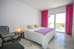 a bedroom with a bed and a chair and a window at Three bedroom apartment La Mairena Elviria in La Mairena +35 photos