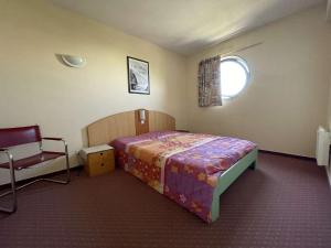 Un dormitorio con una cama y una silla dentro. en Appt 3 pièces LA ROCHELLE - LR010-314, en La Rochelle