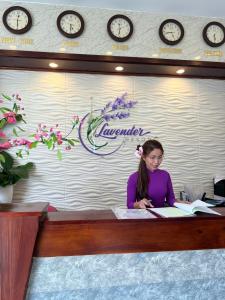 een vrouw aan een bureau met een boek bij Lavender Resorts Phu Quoc in Phu Quoc +42 foto's