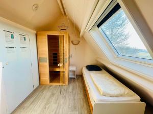 ein kleines Zimmer mit einem Bett und einem Fenster in der Unterkunft Lamsoor 26* in Nieuwvliet