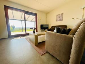 ein Wohnzimmer mit Couch und großem Fenster in der Unterkunft Lamsoor 26* in Nieuwvliet