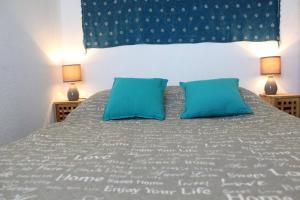 Un dormitorio con una cama grande con almohadas azules. en Appt 2 pièces CHATELAILLON PLAGE - CL040-309, en Châtelaillon-Plage 18 fotos más