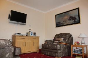 un soggiorno con sedia e TV a schermo piatto di Shiant View a Lochs