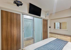 a bedroom with a bed and a tv on the wall at Stylish Genisis on Fairmount U15 in Johannesburg +34 photos