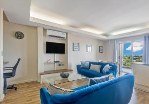 a living room with a blue couch and a tv at Stylish Genisis on Fairmount U15 in Johannesburg