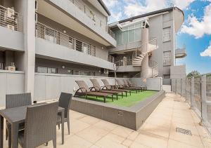a patio with chairs and tables on a building at Stylish Genisis on Fairmount U15 in Johannesburg