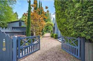 a blue fence in front of a driveway at uffington studio pet friendly garden setting in Daylesford