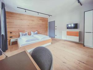 ein Schlafzimmer mit einem Bett und einem Stuhl darin in der Unterkunft Mariandl im Oberwirt in Eggenfelden