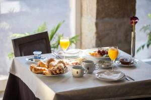 una mesa con alimentos para el desayuno y vasos de zumo de naranja en Casas Novas Countryside Hotel Spa & Events, en Chaves