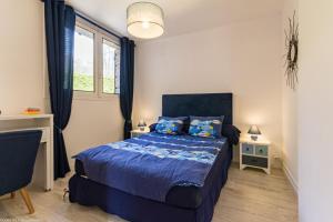 a bedroom with a blue bed and a window at Petit Paradis au coeur du Morvan in Dun-les-Places
