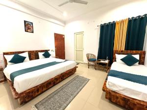 a bedroom with two beds and a chair at GreenDay Escapes Rishikesh in Rishīkesh