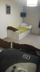 a bedroom with a bed with a yellow blanket on it at Hermine appartement 4 personnes in Vroncourt