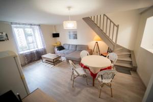 a living room with a couch and a table and chairs at Les gîtes de Véroncourt L'Hermine appartement 4 personnes in Vroncourt