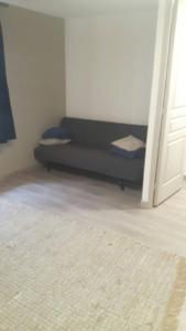 a couch sitting in a room next to a door at Hermine appartement 4 personnes in Vroncourt