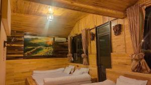a room with two white couches in a wooden room at Nhà hàng Homestay Hương Tây Bắc in Trạm Tấu