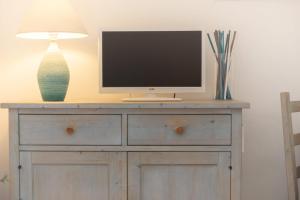 a television on top of a dresser with a lamp at Relaxing Residenzia Palau Green Village M2 Premium Studio Sleeps 2 in Palau