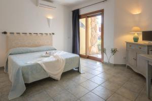 a bedroom with a bed with a table and a window at Relaxing Residenzia Palau Green Village M2 Premium Studio Sleeps 2 in Palau +42 photos