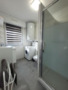 ein Badezimmer mit Toilette und Glasduschtür in der Unterkunft Beau Studio climatisé, parking privé Sanary centre in Sanary-sur-Mer